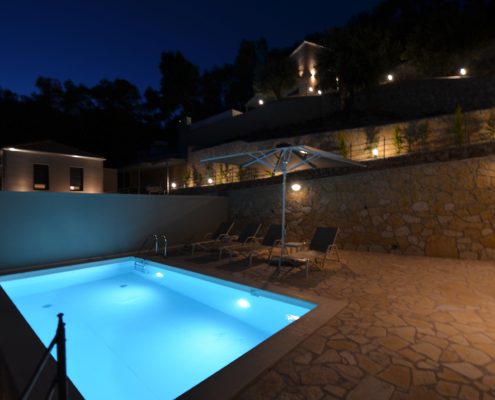 Asaya-Hills-Villas-Parga-Greece-private-villa-exterior-swimming-pool-sunbeds-umbrella-night-holidays Night shot of a lighted swimming pool at the exterior space of a private villa at Asaya Hills Villas, Parga, Greece.
