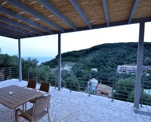 Balcony of a private villa overlooking the sea and green hills at Parga, Greece.